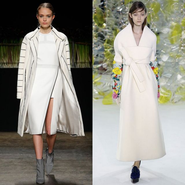 Woman wearing a white midi dress with a front slit, layered under a striped white coat and black ankle boots