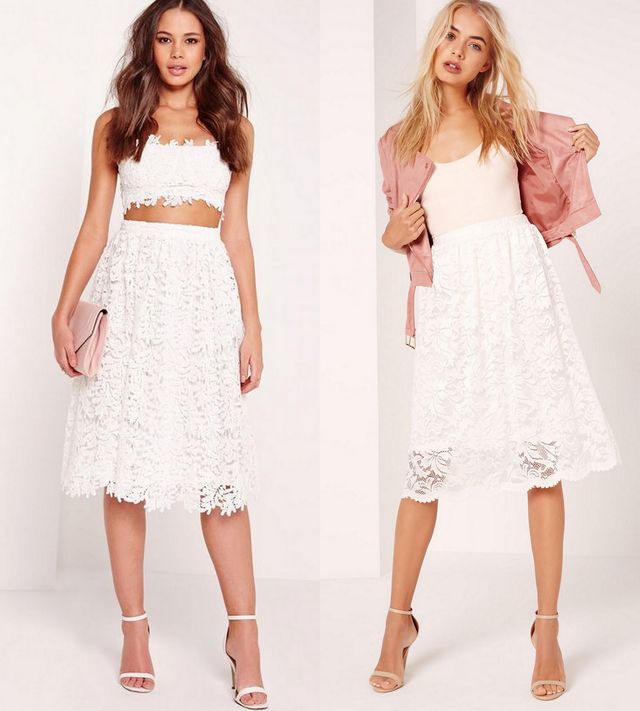 Woman wearing a white lace crop top and white lace midi skirt with nude strappy heels, alongside another woman in a white tank top and white lace midi skirt with a pink bomber jacket and nude heels