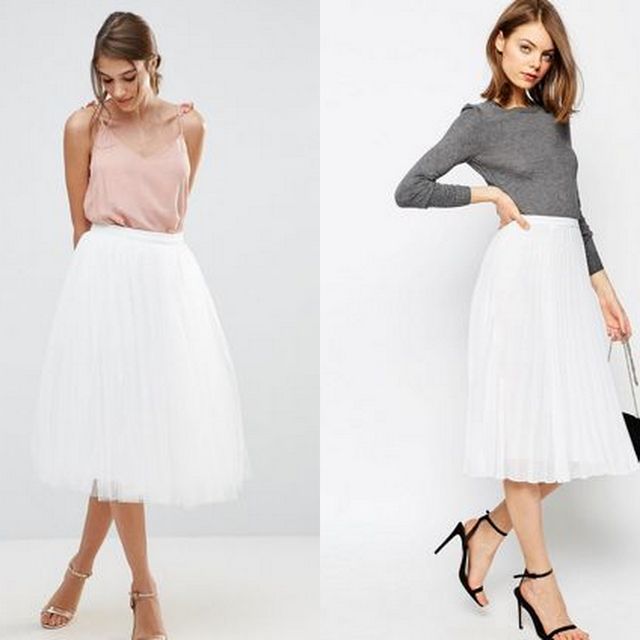Woman wearing a light pink camisole, white pleated midi skirt and clear block-heeled sandals. Woman in a grey long-sleeve top, white pleated midi skirt and black strappy heels