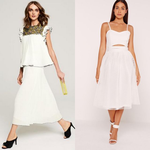 Woman wearing a white pleated maxi dress with a black and gold embellished neckline and black high-heeled sandals