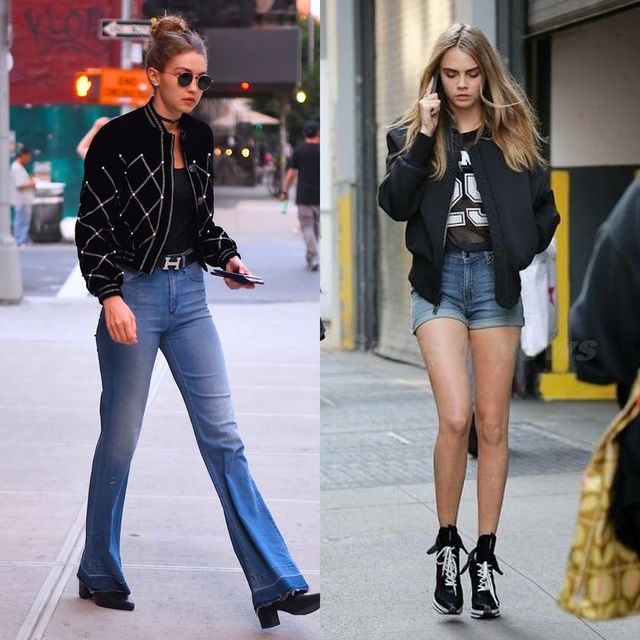 Woman wearing a black and white patterned bomber jacket, black top, flared blue jeans, and black platform boots; woman in a black bomber jacket, graphic tee, and denim shorts with black high-top sneakers