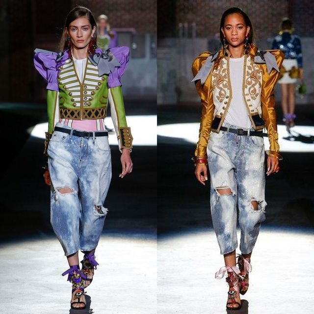 Two women wearing colorful structured jackets, one in purple and green, the other in gold, paired with distressed denim jeans and embellished sandals