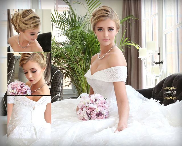 Woman in a white off-the-shoulder wedding dress with lace detailing, holding a bouquet of pink roses and wearing a pearl necklace