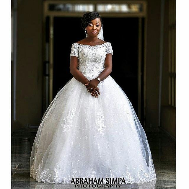 Woman in a white ball gown with lace detailing and a sheer veil