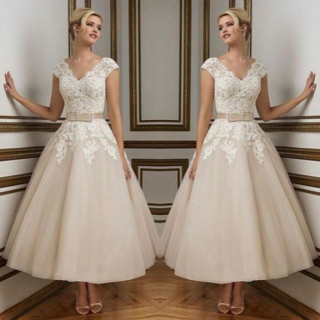 Woman in a beige lace bodice dress with a tulle skirt and nude strappy heels