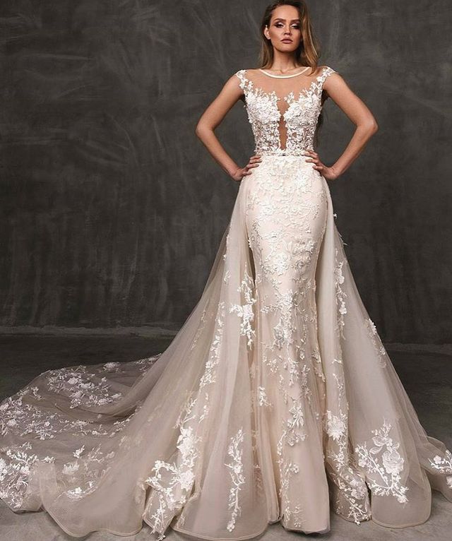 Woman in a nude lace gown with floral embroidery and a sheer train