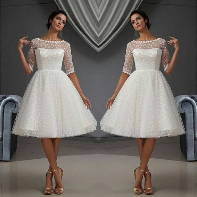 Woman in a white polka dot tulle dress with sheer sleeves and nude strappy heels