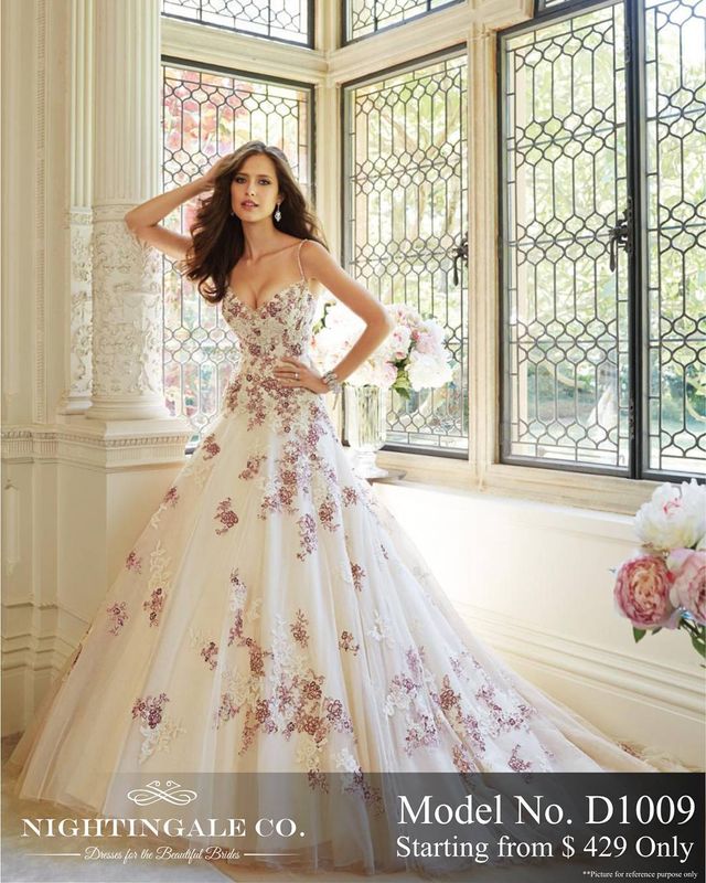 Woman in a white ball gown with floral embroidery and a fitted bodice, featuring a full tulle skirt