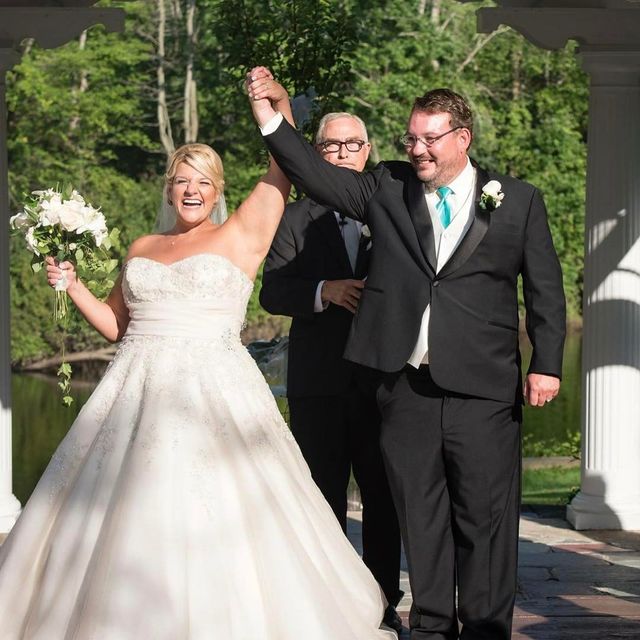 Woman in a white strapless wedding gown with a full skirt, holding a bouquet of white flowers