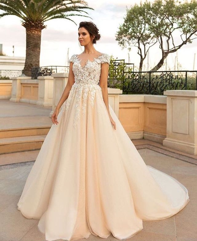 Woman in a nude ball gown with lace detailing and a full tulle skirt