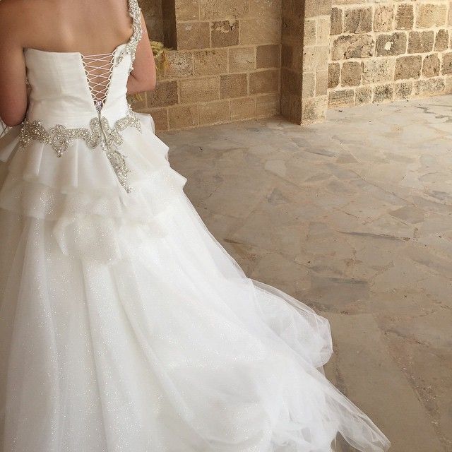 Woman in a white tulle wedding dress with a fitted bodice and embellished back detail