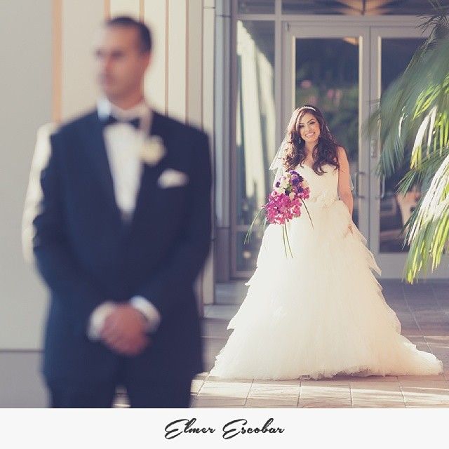 Woman in a white tulle wedding gown holding a bouquet of purple flowers