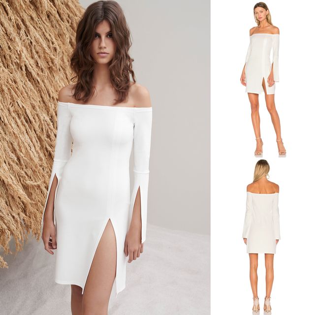 Woman in a white off-the-shoulder dress with long sleeves and side slits, paired with clear heeled sandals