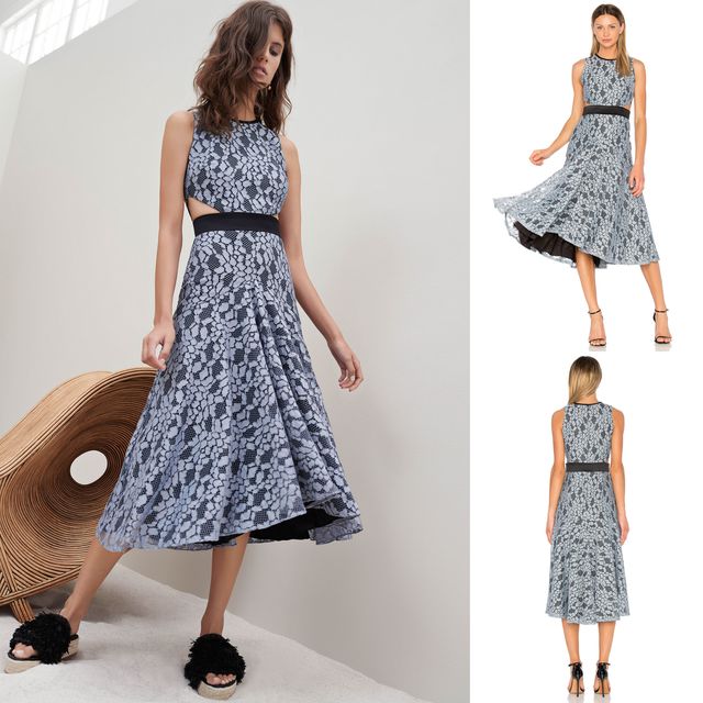 Woman wearing a blue floral midi dress with a black waistband and black slide sandals