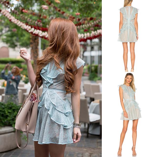 Woman wearing a light blue lace dress with ruffle detailing and a fitted waist, carrying a beige handbag