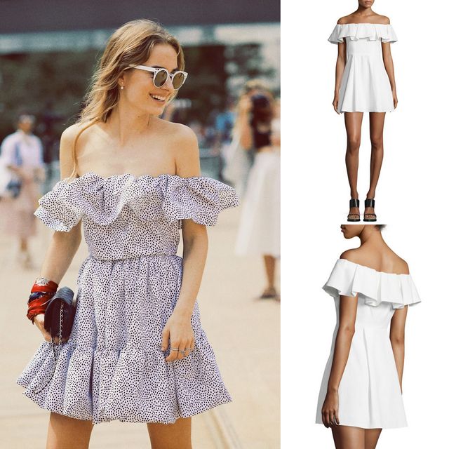 Woman wearing a white off-the-shoulder dress with ruffle details and a flared skirt, accessorized with oversized sunglasses and a black clutch