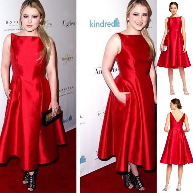 Woman in a red satin fit-and-flare dress with pockets and black strappy heels