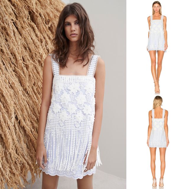 Woman wearing a light blue crochet mini dress with a square neckline and fringe detailing, paired with nude strappy sandals